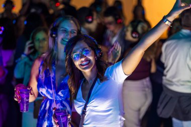 FARO, PORTUGAL: 5 EYLÜL, 2024 - Dinleyiciler F festivalinde kulaklıkla müzik dinliyorlar, sessiz bir disko konsepti..