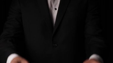 man holding one hundred dollar bills in his hands on a black background. High quality 4k footage