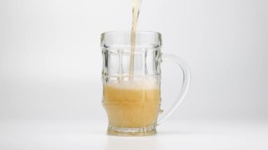 Beer pouring into a glass on white background. Slow motion. High quality 4k footage