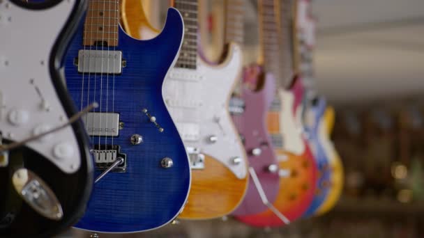 Homem Escolhe Uma Guitarra Elétrica Azul Uma Loja Música Imagens — Vídeo de Stock