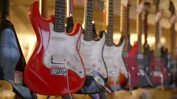 Homem Escolhe Uma Guitarra Elétrica Vermelha Vintage Uma Loja Música — Vídeo de Stock