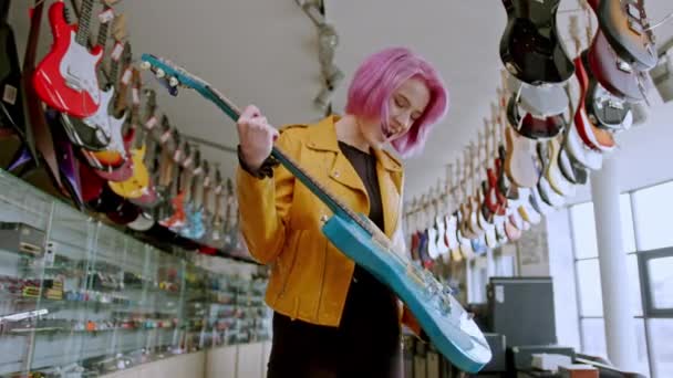 Молода Дівчина Купує Електрогітару Музичному Магазині Щаслива Висока Якість Кадрів — стокове відео