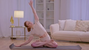 Atletik kız evde esneme hareketleri ve yoga egzersizleri yapıyor. Yüksek kalite 4k görüntü