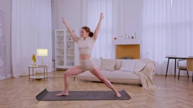 Atletik kız evde esneme hareketleri ve yoga egzersizleri yapıyor. Yüksek kalite 4k görüntü