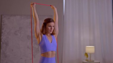 Genç kadın elastik bant kullanarak yoga yapıyor. Yüksek kalite 4k görüntü