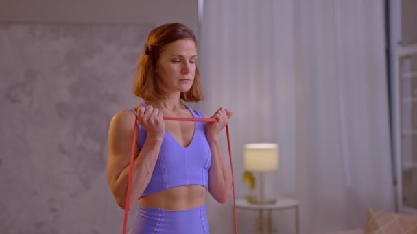 Junge Frau Macht Yoga Übungen Mit Gummiband Hochwertiges Filmmaterial — Stockvideo