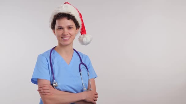 Νεαρή Γυναίκα Νοσοκόμα Στον Άγιο Βασίλη Καπέλο Χέρια Σταυρωμένα Χαμογελώντας — Αρχείο Βίντεο