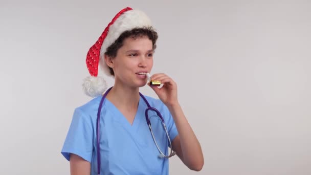 Νοσοκόμα Γιορτάζει Χριστούγεννα Καπέλο Του Βασίλη Φυσάει Στην Πίπα Υψηλής — Αρχείο Βίντεο