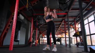 Spor salonundaki kadın spor salonunda çömeliyor. Yan görüş. Yüksek kalite 4K görüntü. yavaş çekim