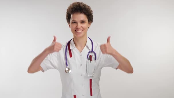 Retrato Feliz Sorrindo Jovem Médico Encaracolado Mostrando Polegares Para Cima — Vídeo de Stock
