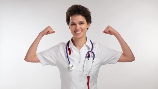 Jovem Curly Feminino Médico Mostra Dupla Postura Bíceps Sobre Fundo — Vídeo de Stock
