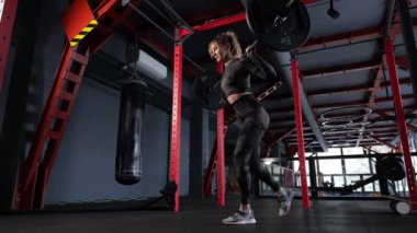 Spor salonundaki kadın halter sallıyor. Yan görüş. Yüksek kalite 4K görüntü. yavaş çekim
