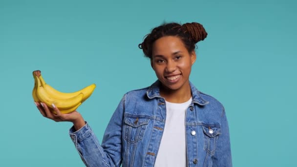 Chica Africana Sostiene Plátano Sus Manos Sonríe Grabado Estudio Imágenes — Vídeo de stock