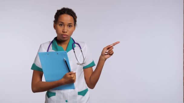 Enfermera Africana Feliz Uniforme Señalando Dedo Esquina Derecha Del Marco — Vídeo de stock