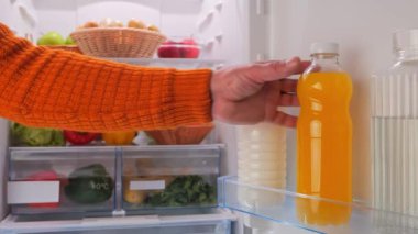 Erkek elleri buzdolabından sebzeli bir şişe portakal suyu alır. Yüksek kalite 4k görüntü