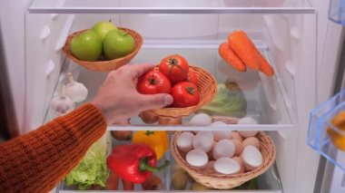 Erkek eli dolaptan sebzeli kırmızı domates alır. Yüksek kalite 4k görüntü