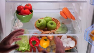 Erkek elleri buzdolabından sebzeli yeşil bir elma alır. Yüksek kalite 4k görüntü