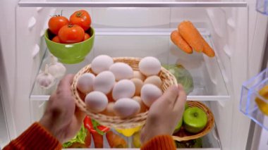 Erkek eli buzdolabına organik tavuk yumurtası koydu. Yüksek kalite 4k görüntü