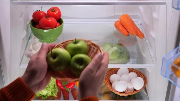 男性の手は野菜と冷蔵庫から緑のりんごのバスケットを置きました 高品質の4K映像 — ストック動画