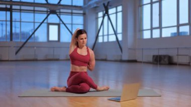 Atletik kız dizüstü bilgisayarla online yoga dersi veriyor. Yüksek kalite 4k görüntü