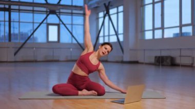 Atletik kız dizüstü bilgisayarla online yoga dersi veriyor. Yüksek kalite 4k görüntü