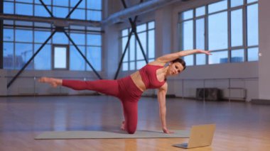 Atletik kız dizüstü bilgisayarla online yoga dersi veriyor. Yüksek kalite 4k görüntü