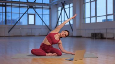 Atletik kız dizüstü bilgisayarla online yoga dersi veriyor. Yüksek kalite 4k görüntü