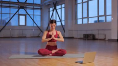 Atletik kız dizüstü bilgisayarla online yoga dersi veriyor. Yüksek kalite 4k görüntü
