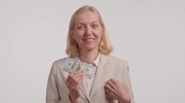 Paraya bayılırım. Para sayan, paralı, mutlu, yetişkin bir kadın. Dolar banknotları. Elinde bir sürü para tutan adamın portresi.. 