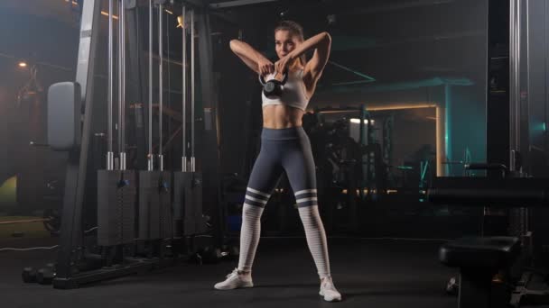 女性はジムでケトルベルでスカートを行い 彼女の太い筋肉を働かせ 体力のために彼女のコアを引き付ける — ストック動画