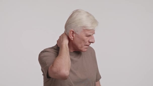 Öregember Vigyorog Fájdalomtól Miközben Nyakát Fogja Egy Ujjal Integet Füle — Stock videók