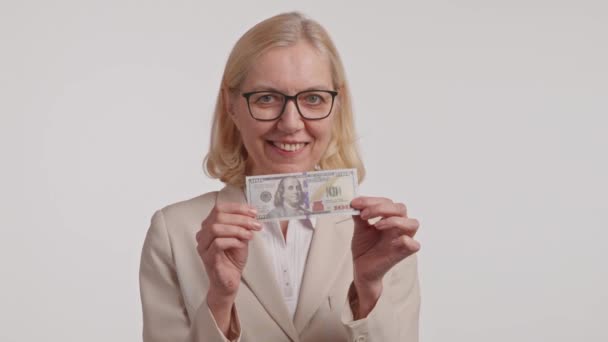 Μια Γυναίκα Γυαλιά Και Κοστούμι Χαμογελάει Κρατώντας Μια Στοίβα Λεφτά — Αρχείο Βίντεο