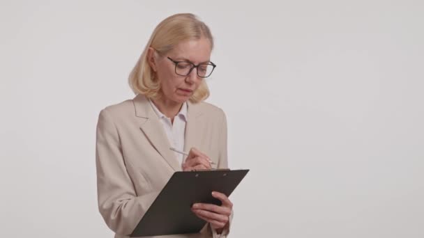 Uma Mulher Uso Formal Óculos Está Sentada Segurando Uma Prancheta — Vídeo de Stock