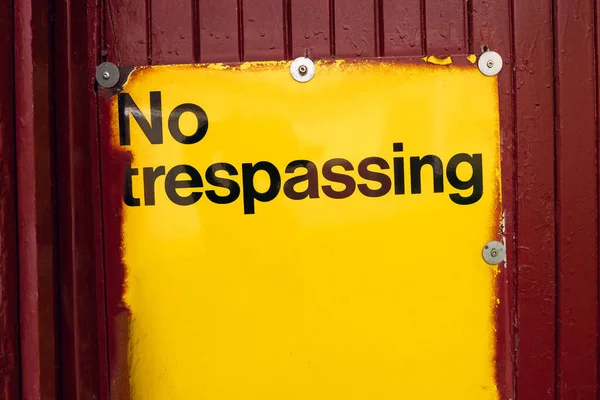 Inscription Trespassing Yellow Plate Red Door Private Territory Ban Entering — Stock Photo, Image