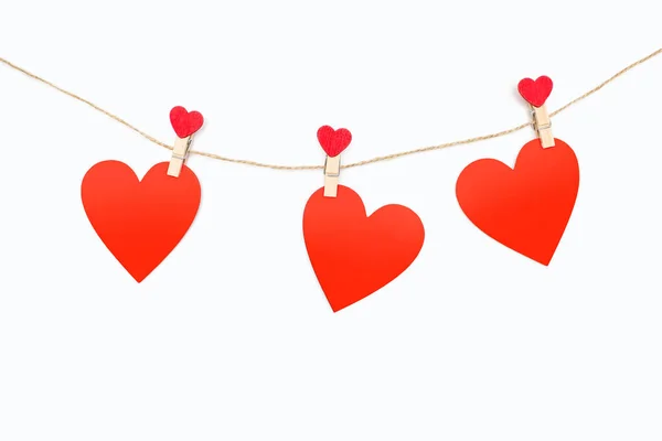 Три Красных Сердца Прикреплены Веревке Прищепками Белом Фоне Декор Виде — стоковое фото