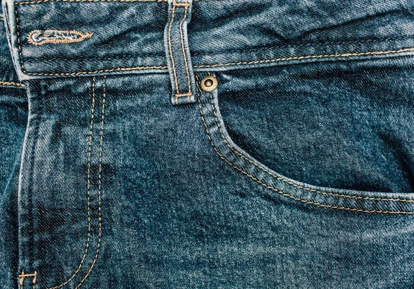Blue trendy jeans close-up with pocket view. Denim background and fabric texture. Free space for text. Wide leg indigo jeans. Front jeans pocket