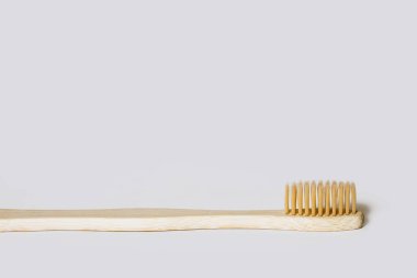 Wooden toothbrush on a white isolated background. Environmentally friendly plastic-free toothbrush. Free space for text. Zero waste personal hygiene products, dental care concept