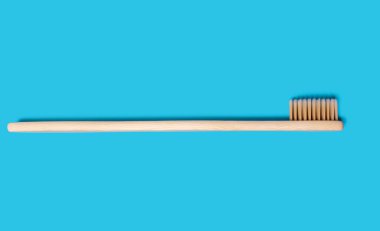 Ecological wooden toothbrush on a blue background. Wooden toothbrush without plastic. Waste-free personal care products, dental care concept