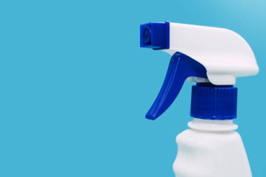 Plastic white spray on a blue background. Detergent for cleaning and disinfecting rooms, cleaning and washing windows or dishes with a spray function. Free space for text
