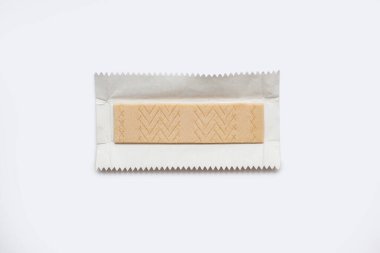 Beyaz bir arka planda paketlenmemiş bir ambalajda sakız parçası. Lezzetli sakız yemekten sonra nefesi ve temiz dişleri tazelemek için kullanılır. Sakız çiğneme alışkanlığı.