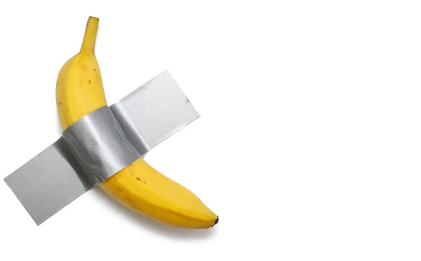 Uma Banana Colada Uma Parede Branca Com Fita Cinza Olhar Fotos De Bancos De Imagens