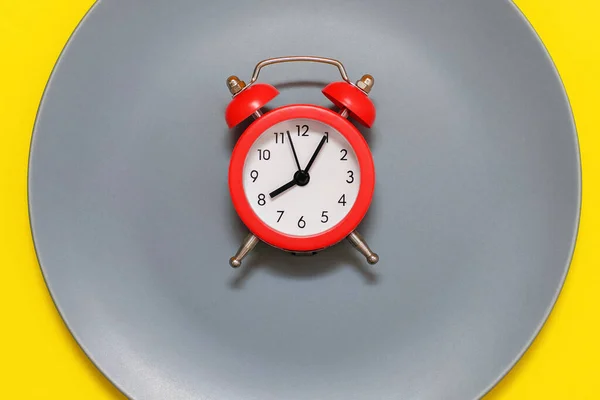 Ένα Κόκκινο Ξυπνητήρι Βρίσκεται Ένα Πιάτο Κίτρινο Φόντο Έννοια Της — Φωτογραφία Αρχείου