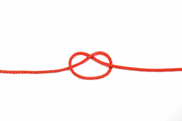 红色的绳子 结不完全绑在白色孤立的背景上 红色尼龙绳 中间有一个解开的结 不耦合的任务或需要解决的问题的结的概念 — 图库照片