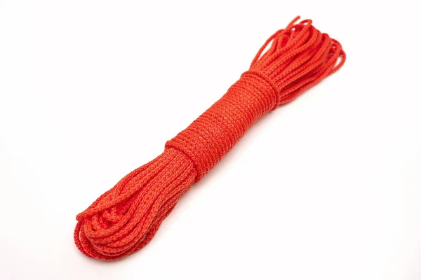 白色背景上的一束整齐扭曲的红色尼龙绳 红绳呈对角线状排列在白色孤立的背景上 红绳形式的经济活动工具 — 图库照片