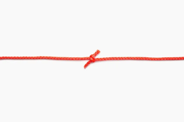 红色绳子的两端绑在一个白色孤立的背景上的结 红色的尼龙绳 中间有一个结 提供免费的文字和广告空间 — 图库照片