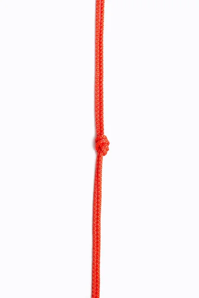 Красная Веревка Узлом Центре Белом Вертикальном Фоне Красная Нейлоновая Веревка — стоковое фото