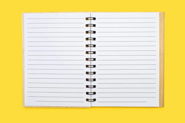 黄色の背景に空のシートでバインドされたノートブックを開きます テキストのための無料スペース ノートパッドの形で文房具を書くことができます 文書の学習又は作業の概念 — ストック写真