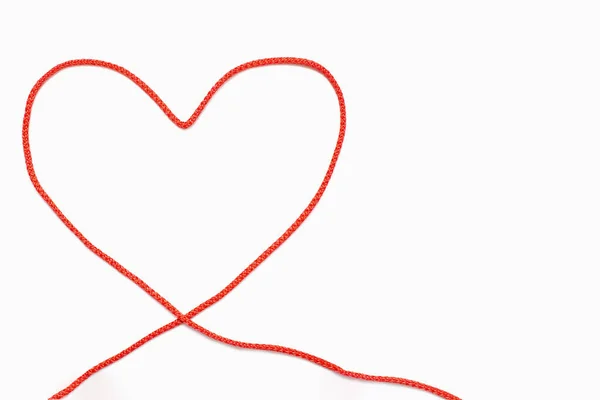 白い孤立した背景に心の形で赤いロープ ハート型に折られた赤いロープの形をした愛の概念 赤い糸の心臓のトップビュー テキストのためのフリースペース — ストック写真