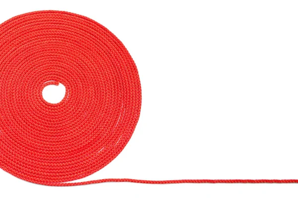 白い孤立した背景に赤いロープの丸いロール きれいにねじれたナイロンロープ 家庭のニーズのための赤い繊維ロープの束 テキストのためのフリースペース — ストック写真