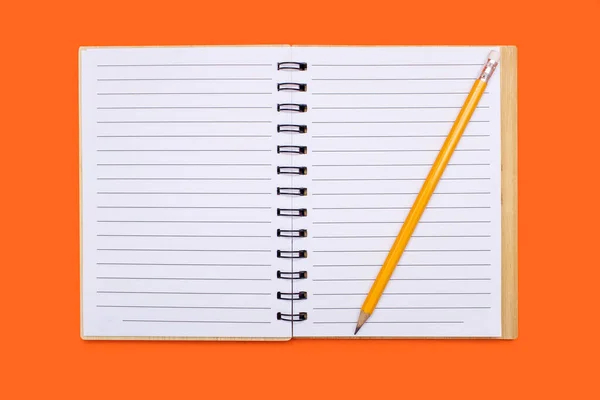 一个打开的笔记本 有一个粘合剂和一支黄色铅笔在橙色的背景上 打开记事本 上面有空白的单子 自由的文字空间 可用于设计的空白笔记本电脑页 — 图库照片